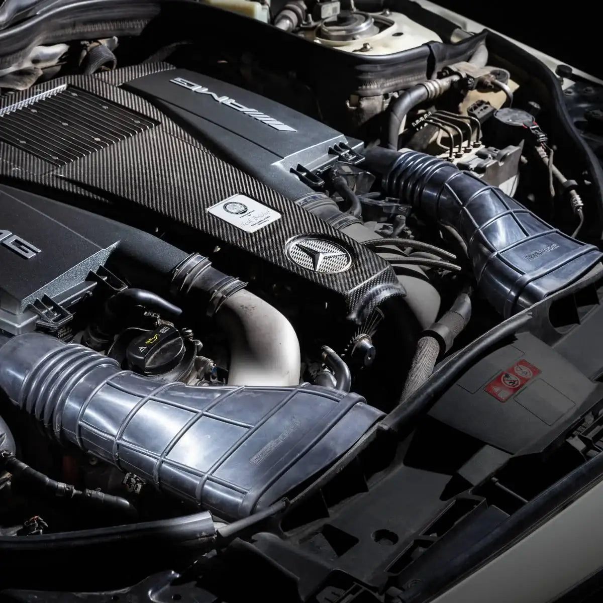 Mercedes AMG Motorraum mit Carbon-Abdeckung und Tuning-Luftkanälen, hochwertige Autoteile