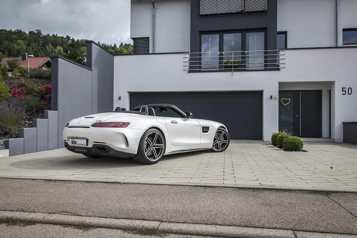 Weißer Mercedes-Benz AMG GT Cabrio mit Sportfelgen vor modernem Haus, Tuning Onlineshop