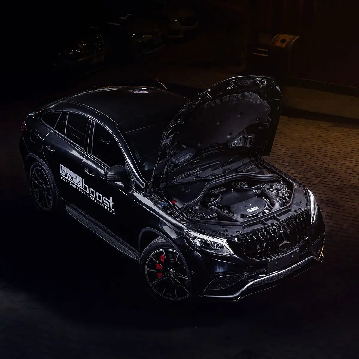 Mercedes-Benz GLE63 mit offenem Motorraum und Tuning-Lufteinlass, Blackboost Aufkleber, Nachtszene