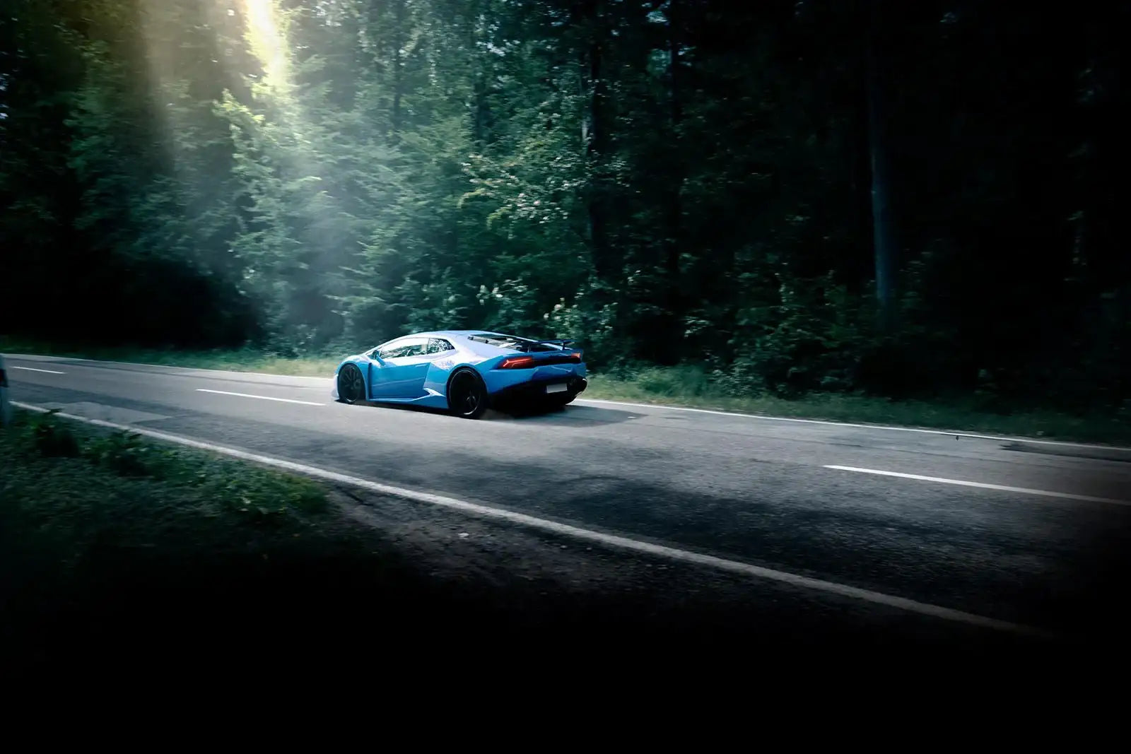 Blauer Sportwagen auf Landstraße im Wald, Tuning-Auto für KTH Shop, Tuningteile online