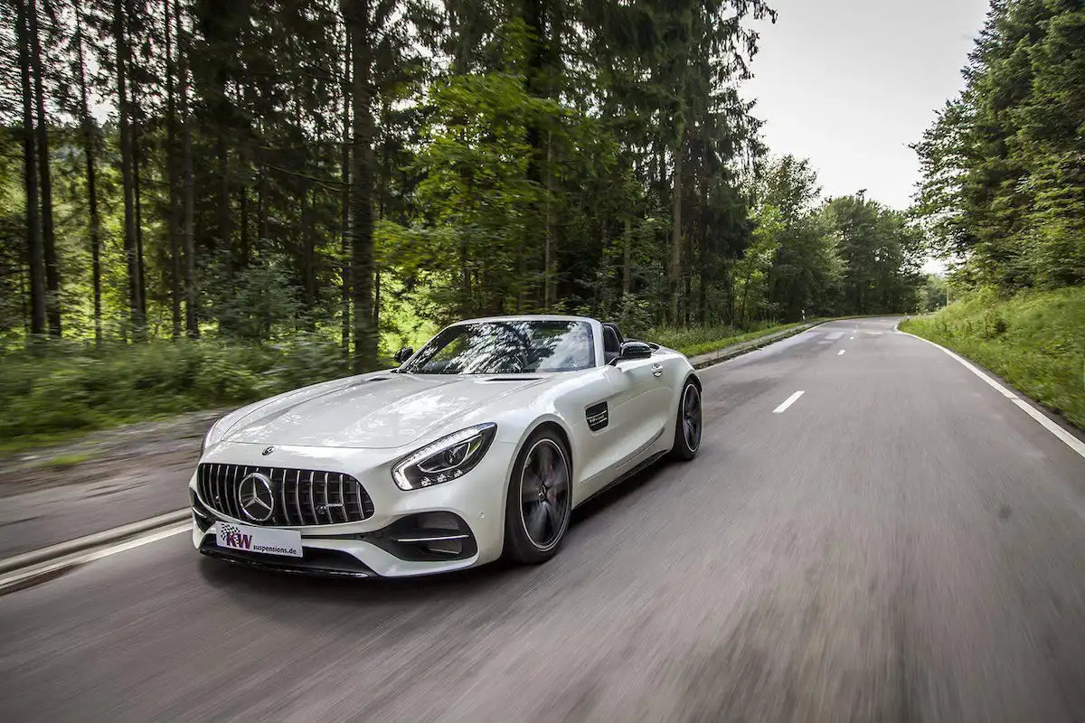 Weißer Mercedes-Benz AMG GT Cabrio fährt auf kurviger Landstraße im Grünen, KTH Shop Tuning