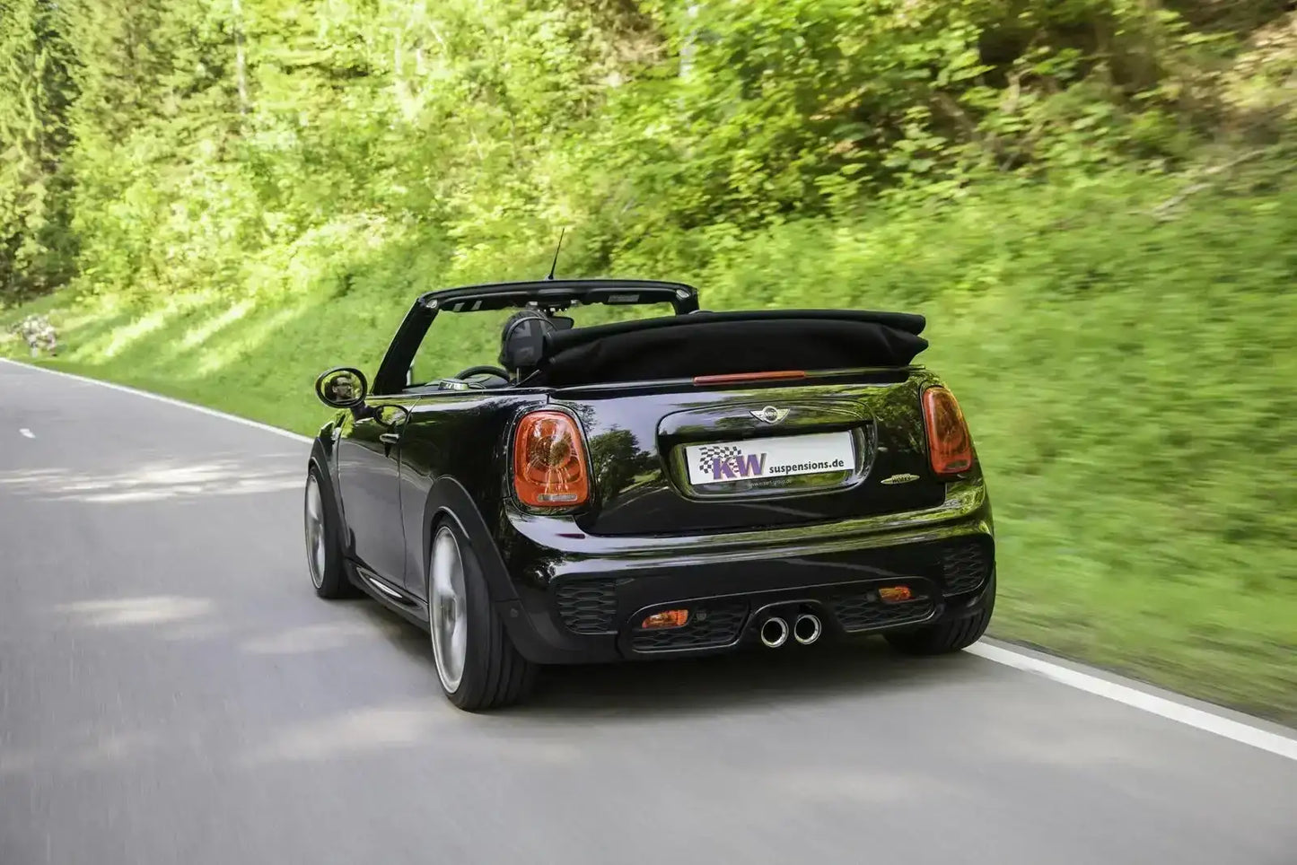 Schwarzer Mini John Cooper Works Cabrio fährt auf Landstraße, Tuningteile KTH Shop, Sommer