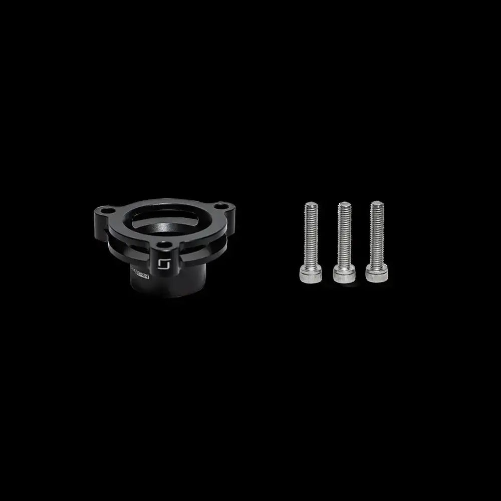 Mercedes M256 FTA Adapter mit drei Schrauben, schwarzes Tuning-Teil vor schwarzem Hintergrund