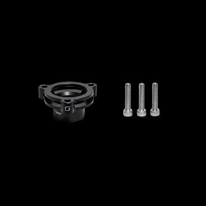 Mercedes M256 FTA Adapter mit drei Schrauben, schwarzes Tuning-Teil vor schwarzem Hintergrund
