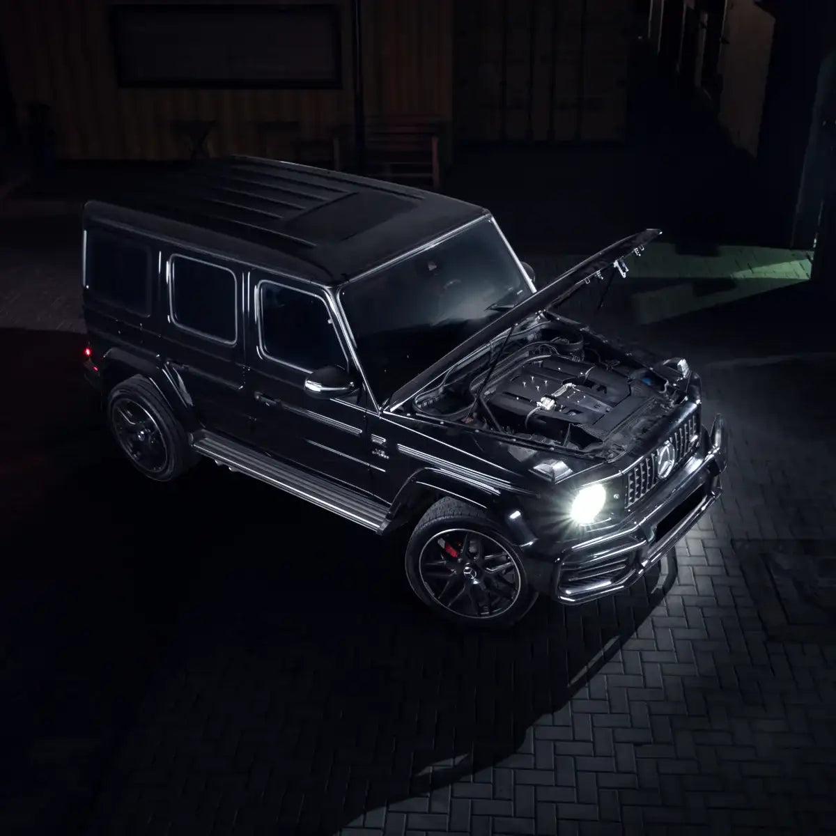 Mercedes G500 mit geöffnetem Motorraum und Cold Air Intake, Nachtaufnahme, Tuning-Teile online