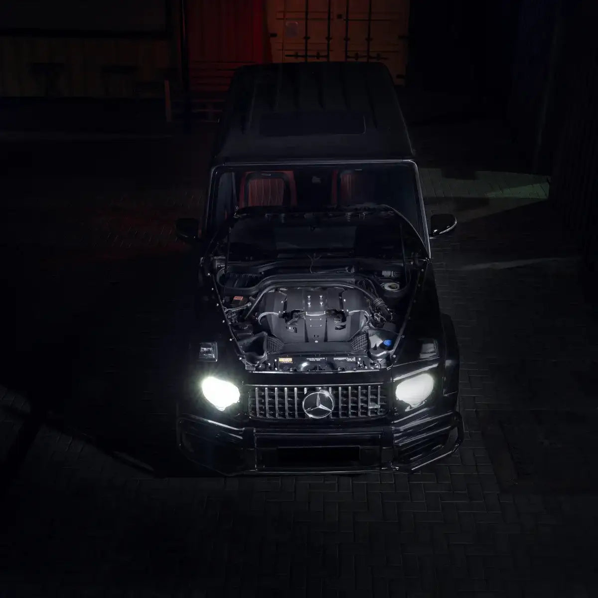 Mercedes G500 mit installiertem Cold Air Intake, Motorhaube offen, Frontansicht bei Nacht