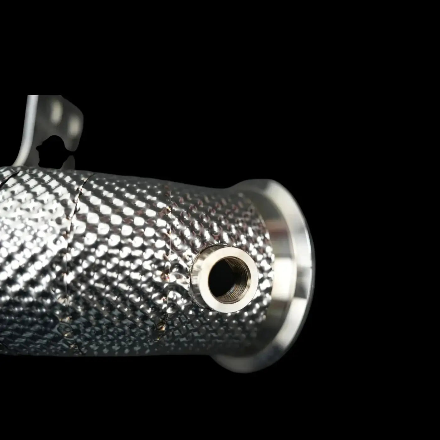 Detailaufnahme eines hochwertigen, metallischen Tuning-Teils mit Gewindeöffnung vor schwarzem Hintergrund aus dem KTH Shop.