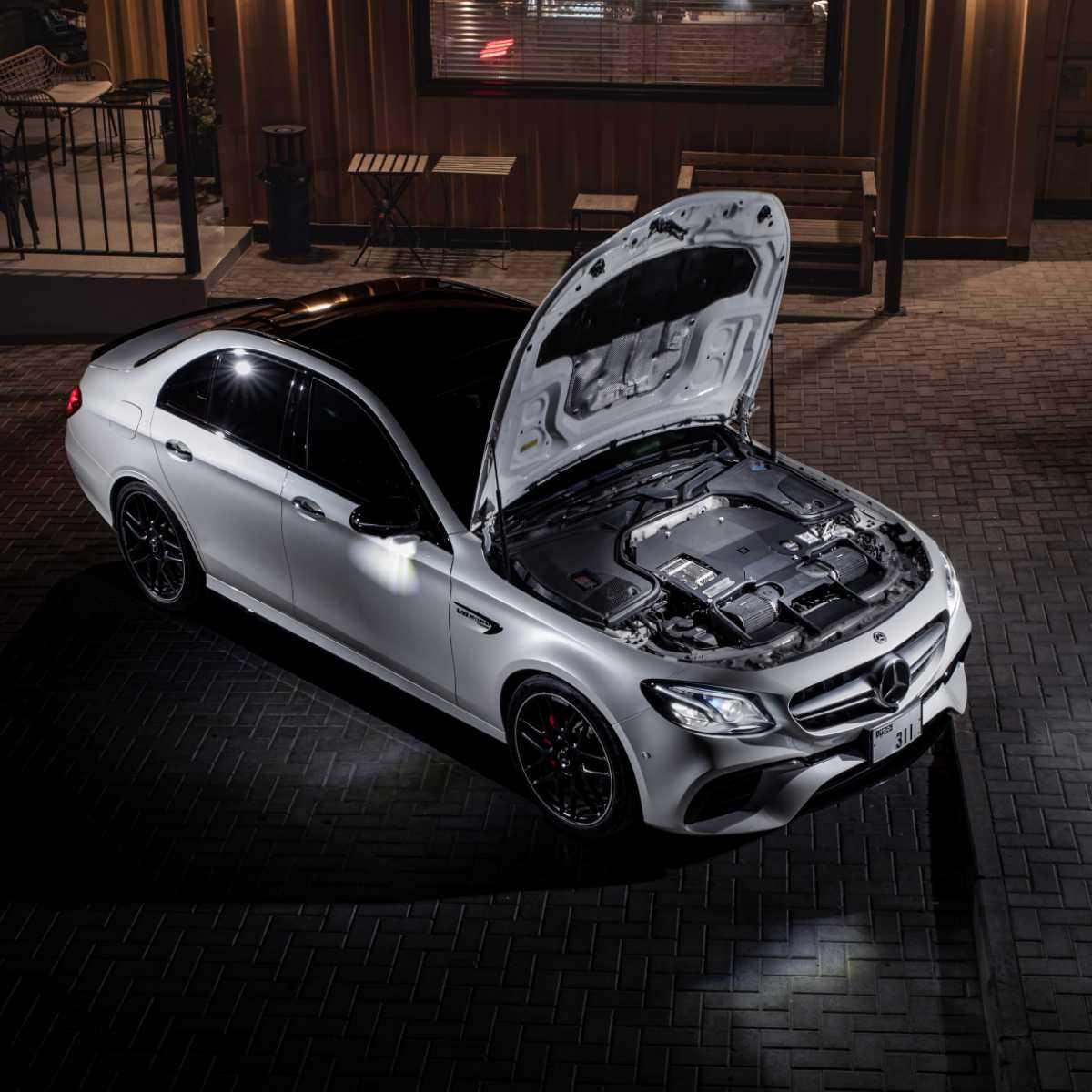 Mercedes-Benz Limousine mit geöffnetem Motorraum, hochwertige Tuning-Teile sichtbar, nachts